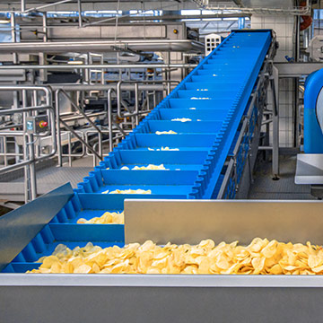 Incline conveying of potato chips and snack foods