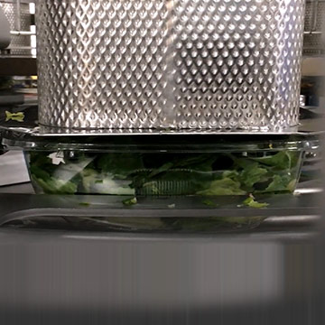 Machine filling trays with salad