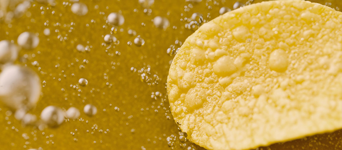 Freír patatas fritas redondeadas con burbujas de aceite hirviendo