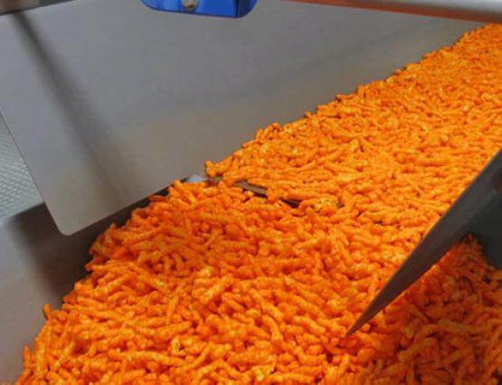 Seasoned corn curls conveyed on Horizontal Motion Conveyor