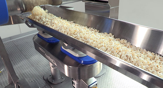 Conveying popcorn and snack foods