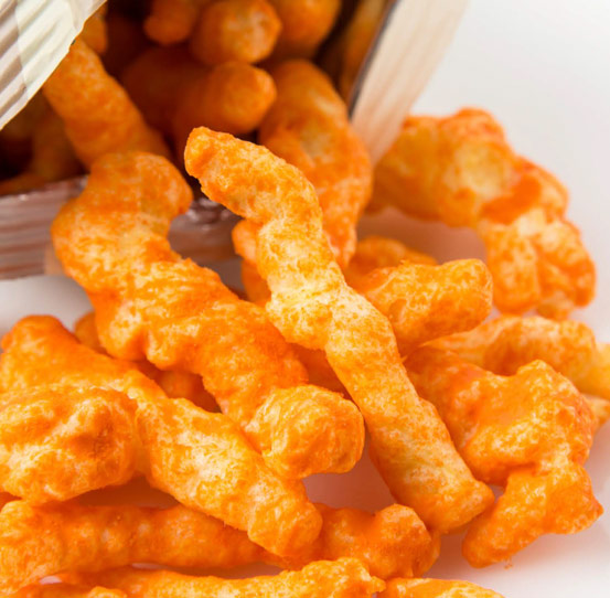 Cheese puffs and extruded snacks seasoned with slurry mixture
