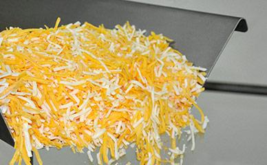 Conveying shredded cheese to weighers