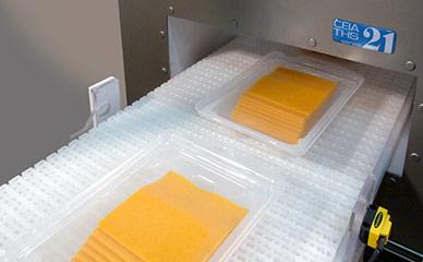 Running cheese through metal detector for food safety