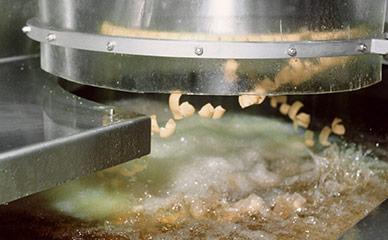Extruding corn chips into fryer